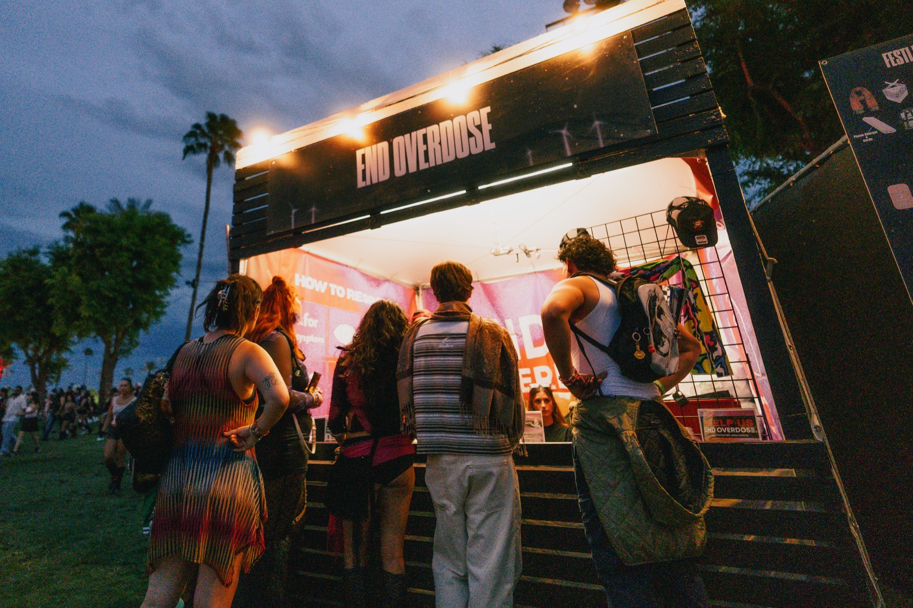The End Overdose booth at a festival at night, with people lining up for training